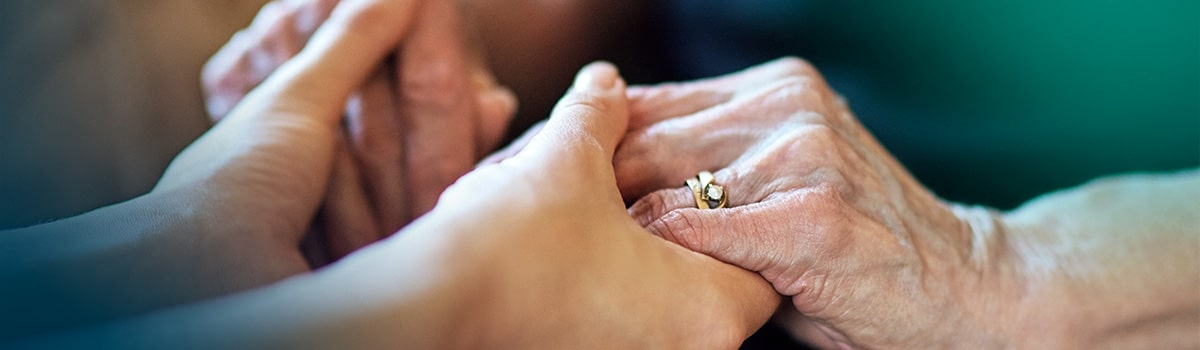 cuidador-segurando-mao-de-idoso